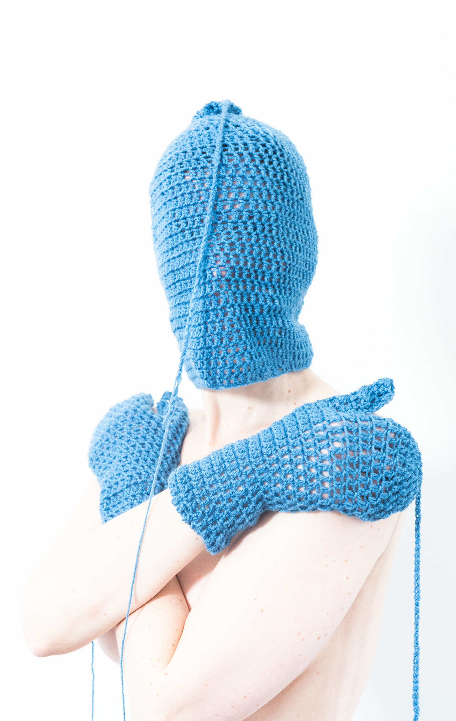 Mask — blauw gehaakt masker met wanten over kruislings gehouden armen